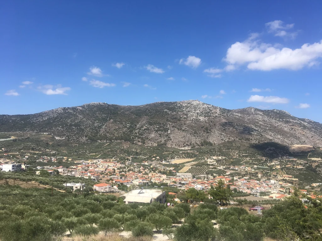 Η κωμόπολη των Αρχανών περιτριγυρισμένη από ελαιώνες και βουνά, μια ηλιόλουστη μέρα του Αυγούστου