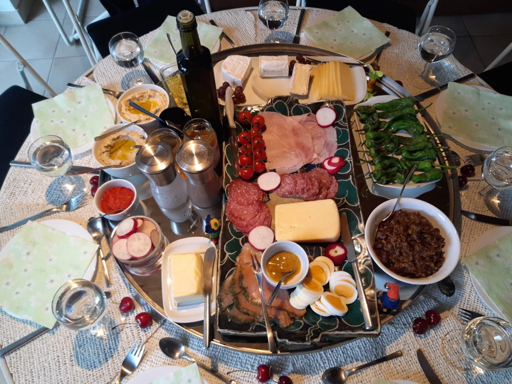 Στρογγυλό τραπέζι brunch με αλλαντικά, τυριά, βραστά αυγά, ντοματίνια, πιπεριές και αλείμματα σε μπολ