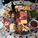 Στρογγυλό τραπέζι brunch με αλλαντικά, τυριά, βραστά αυγά, ντοματίνια, πιπεριές και αλείμματα σε μπολ