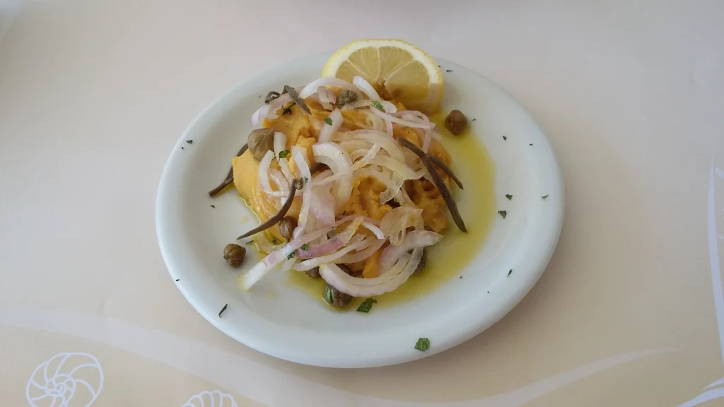 Πιάτο με φάβα, ψιλοκομμένο κρεμμύδι, κάπαρη, κρίταμο, ελαιόλαδο και μια φέτα λεμόνι