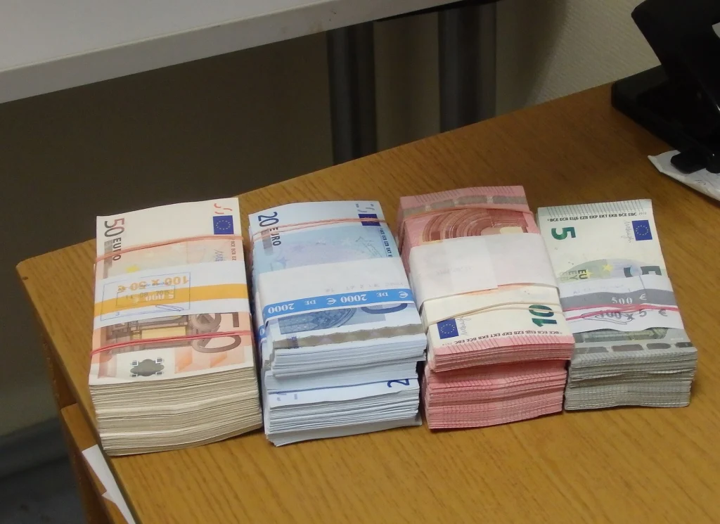 Δέσμες χαρτονομισμάτων ευρώ των 5, 10, 20 και 50 ευρώ πάνω σε ξύλινο γραφείο