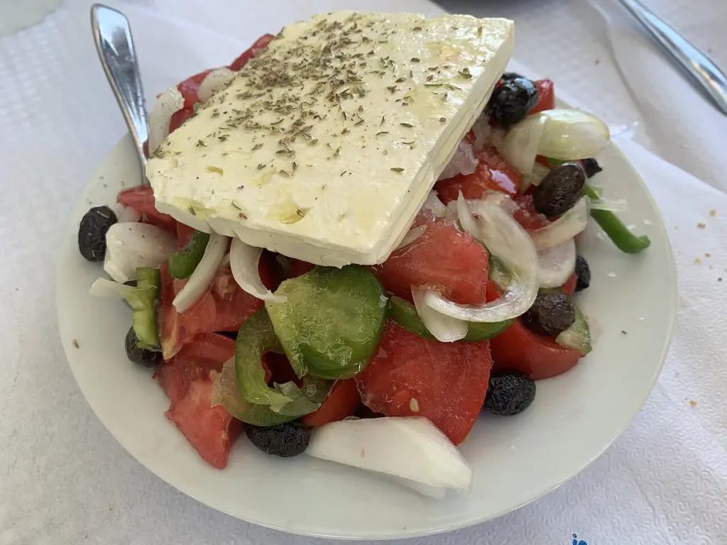 Χωριάτικη σαλάτα με ντομάτα, κρεμμύδι, πράσινη πιπεριά, ελιές και ένα κομμάτι λευκό τυρί με ρίγανη σε πιάτο