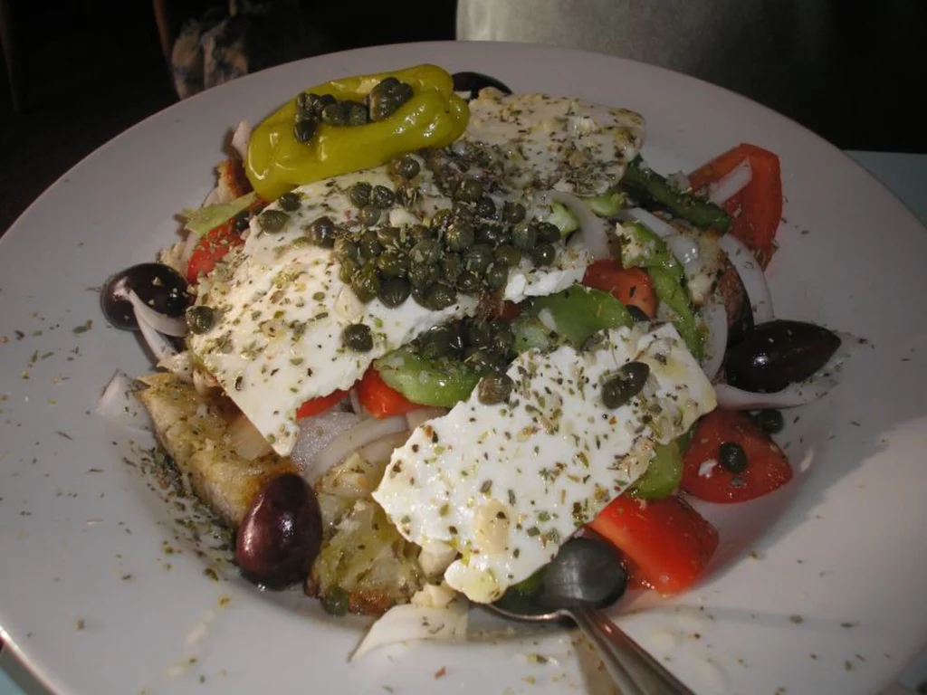 Σαλάτα με πολλή κάπαρη πάνω από κομμάτια λευκού τυριού, ελιές, ντομάτα, πιπεριά και φρυγανισμένο ψωμί