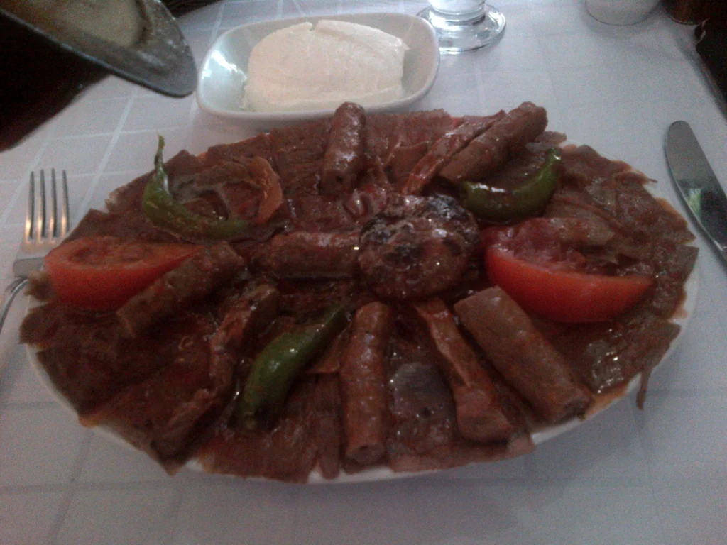 Πιάτο ισκεντέρ (κεμπάπ Προύσας) με φέτες ντονέρ, κομμάτια κεμπάπ, ντομάτα, πιπεριές και γιαούρτι στο πλάι