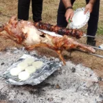 Αρνί και κοκορέτσι σε σούβλες με μοτέρ πάνω από κάρβουνα, σε πασχαλινό ψήσιμο στην ύπαιθρο