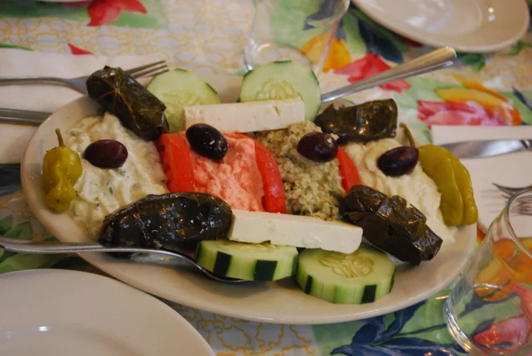 Πιατέλα μεζέδων με αλείμματα, ντολμαδάκια, φέτα, ελιές και φέτες αγγουριού σε οβάλ πιάτο