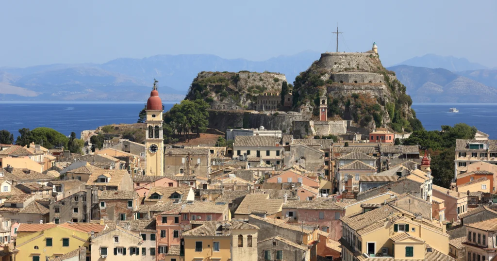 Θέα από ψηλά στα κεραμίδια της Παλιάς Πόλης της Κέρκυρας με το Παλαιό Φρούριο και τη θάλασσα πίσω