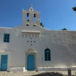 Λευκός ναός της Παναγίας Ουρανοφόρας με καμπαναριό και μπλε πόρτες στην Απολλωνία της Σίφνου