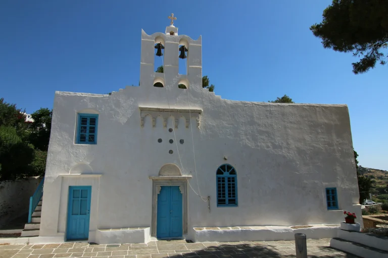 Λευκός ναός της Παναγίας Ουρανοφόρας με καμπαναριό και μπλε πόρτες στην Απολλωνία της Σίφνου