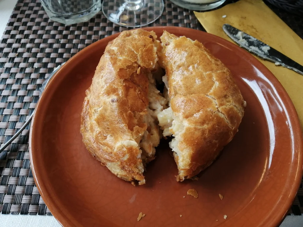 Ιταλικό pasticcio di maccheroni alla ferrarese, πίτα με ζύμη που έχει ανοίξει και δείχνει γέμιση με μακαρόνια