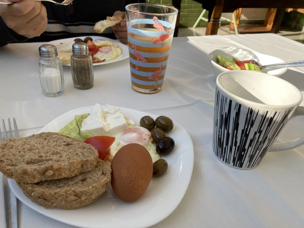 Πιάτο πρωινού από μπουφέ ξενοδοχείου με φέτα, ελιές, αυγό μάτι, βραστό αυγό, ντομάτα και ψωμί