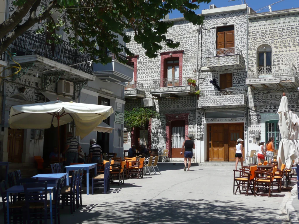 Πλατεία στο Πυργί της Χίου με σπίτια διακοσμημένα με ξυστά και τραπεζάκια