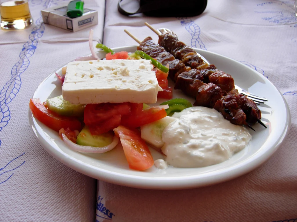 Πιάτο με σουβλάκι, φέτα, ντομάτα, αγγούρι και τζατζίκι σε τραπέζι ταβέρνας στη Λευκάδα
