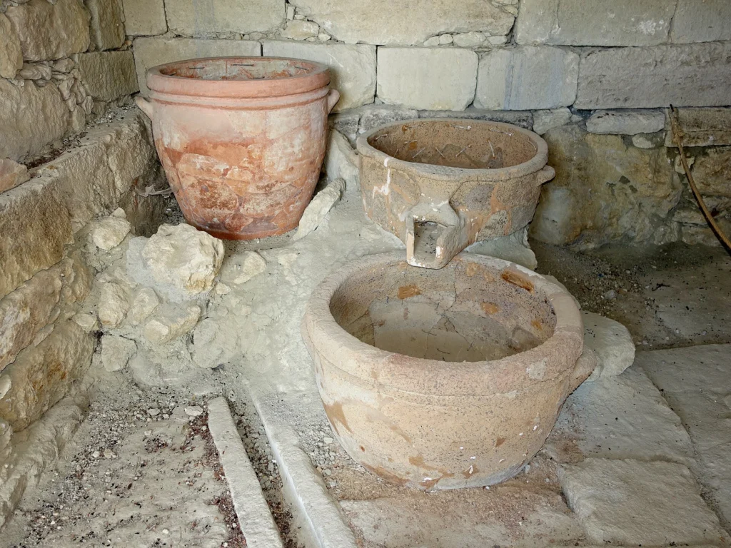 Πήλινα αγγεία και πέτρινη κατασκευή του μινωικού πιεστηρίου κρασιού στο Βαθύπετρο Αρχανών
