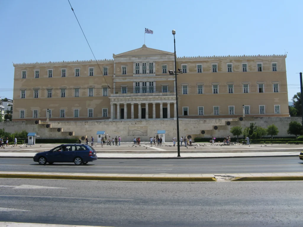 Η πρόσοψη του κτιρίου της Βουλής των Ελλήνων στην πλατεία Συντάγματος, με την ελληνική σημαία